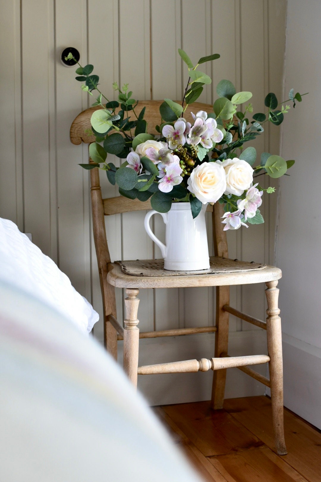 Country floral arrangement with roses, hydrangeas and eucalyptus foliage.