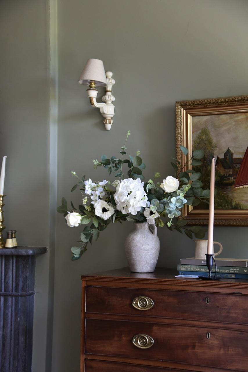 Close up of white hydrangeas, cosmos, roses and wild eucalyptus styled on a wooden table