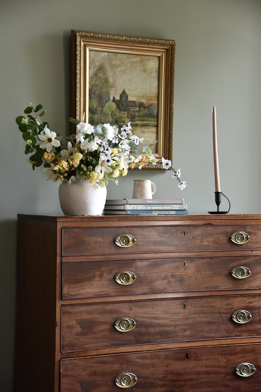 Large Ivory and Yellow Flower Arrangement including white blossom, yellow catmint flowers, stephanotis, magnolias, yellow carnations and green eucalyptus  on wooden drawers and green wall behind